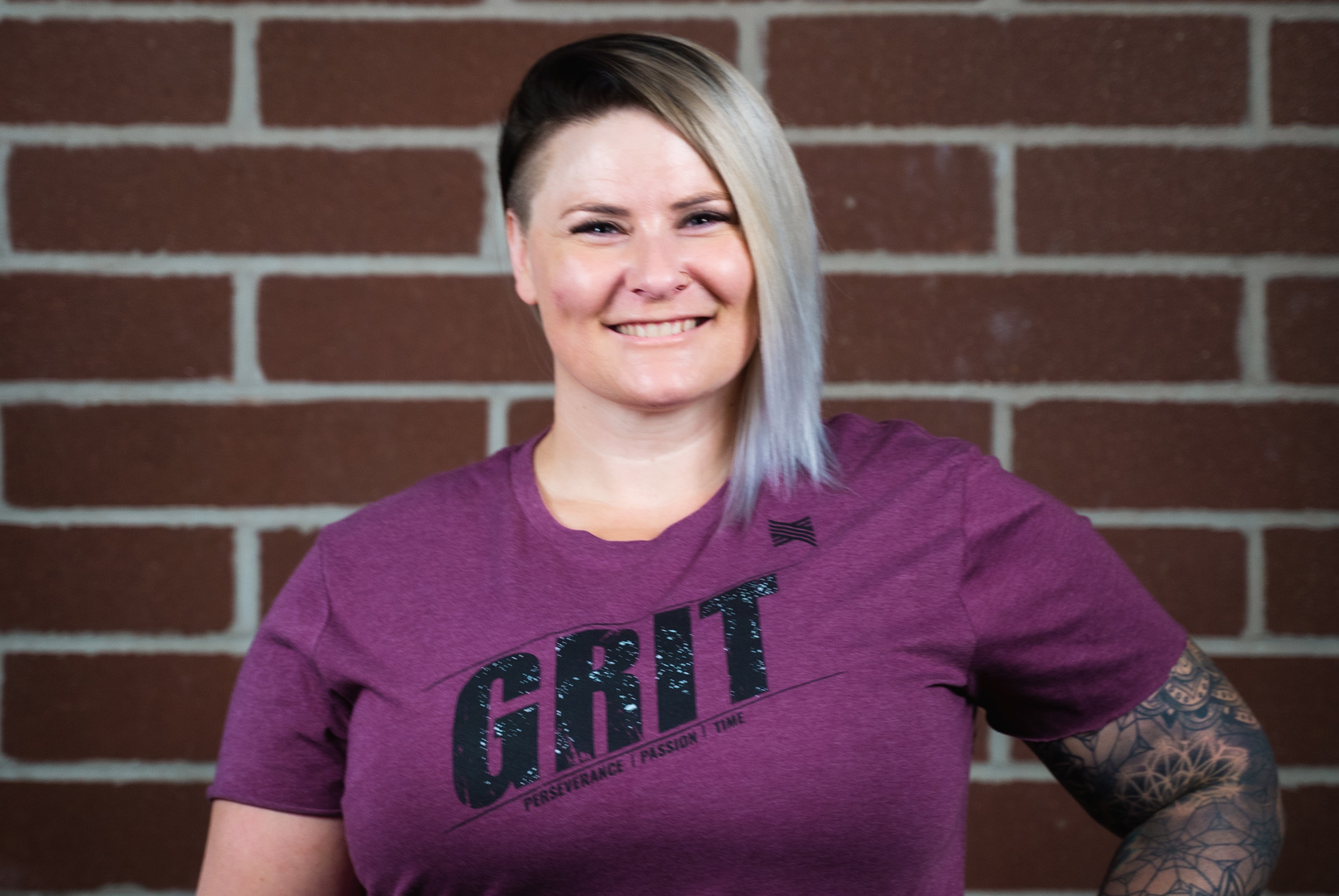 woman wearing Grit t-shirt who does at-home workout programs and true grit